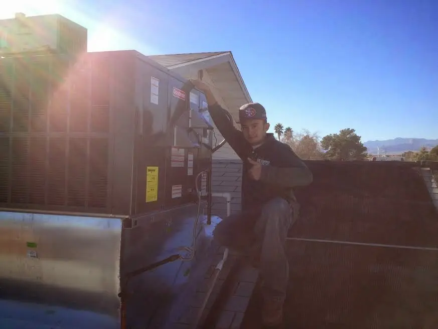 HVAC technician performing HVAC Inspection on a rooftop unit in Upton